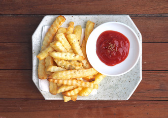 Luxary big pieces of French fries serve with ketchup on wooden background