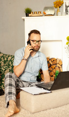 a man in pajamas works from home with a laptop computer