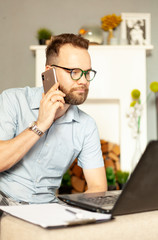 a man in pajamas works from home with a laptop computer