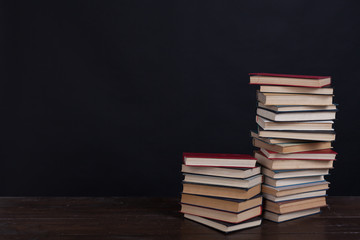 many stacks of educational books to teach in the library on a black background