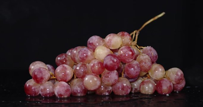 A bunch of grapes slowly rotating cool steam.