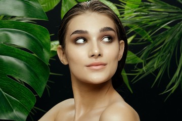 beautiful woman naked shoulders green leaves makeup