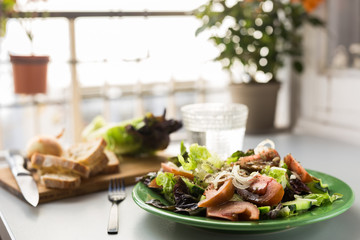 vegetable salad of greens, tomatoes and cucumbers on a green plate