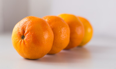 appetizing tangerines laid out in a row on white background