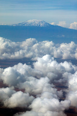 Aerial image of Mount Kilimanjaro, Africa's highest mountain, with snow and white puffy clouds from Kenya