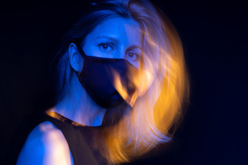 Stunning blonde woman in face mask. Personal breathing respirator protection. Looking to the...