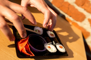 I love sushi very much. hands grab a box of sushi greedily.