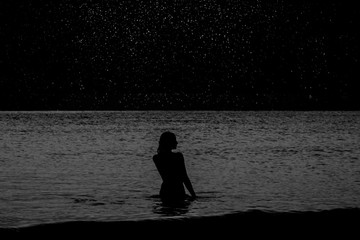 girl in the sea against the starry sky