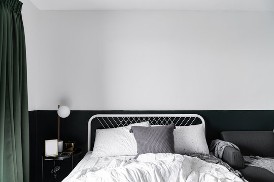 Stylish Two Tone Green And White  Bedroom Corner With Decorative Frame And Plant In Scandinavian Style Apartment