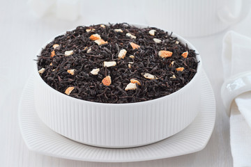 black tea with orange zest on a white background