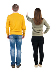 Back view of couple in sweater pointing.