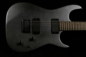 Naklejka na ściany i meble Grey electric guitar on a black background
