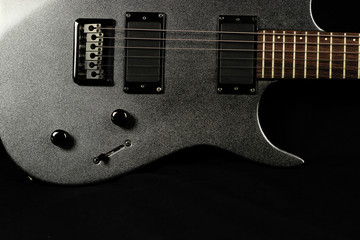 Fototapeta na wymiar Grey electric guitar on a black background