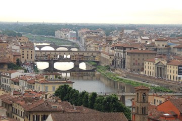 Fototapeta na wymiar View of the city of Florence Italy from above at sunset highlights the Ponte Vecchio.