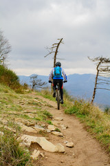 Escursionista in sella ad una Mountain bike percorre un sentiero sulle alture di Genova, Liguria, Italia
