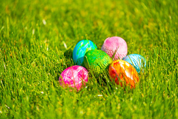 sunny, bright, vibrant Easter background, hand-painted eggs on the background of grass and spring flowers