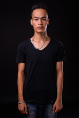 Portrait of young handsome Indian man looking at camera