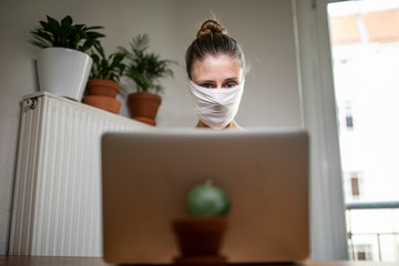 Woman with a mask in home office during Corona Virus time