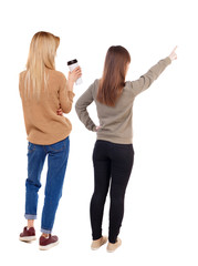 Back view of two pointing girl in sweater.