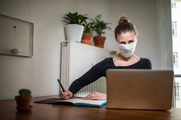 Woman with a mask in home office during Corona Virus time