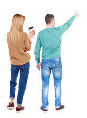 Back view of couple in sweater pointing.