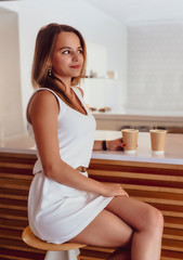 Young beautiful girl holding a cup of coffee in cafe. Outdoor portrait of young beautiful woman posing while traveling holiday vocation. Girl with coffee. Female traveler, travel vacation fun summer.
