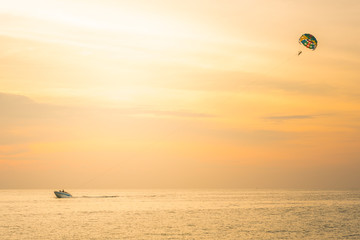 Tourists para-sailing in sunset time at Phuket Beach, Thailand