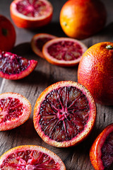 Fresh sliced blood oranges on a wooden cutting board. Low key. Rustic. Close up.