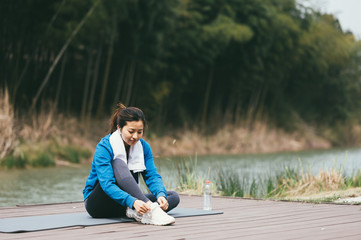 young asian beauty woman doing yoga beside the lake