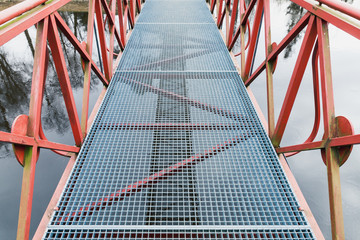 Modern metal bridge view with red handrails