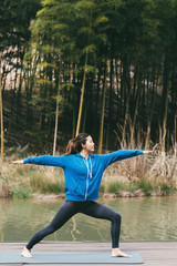 young asian beauty woman doing yoga beside the lake