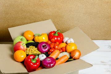 Food in a cardboard box. Vegetables, fruits, pasta, rice. Food delivery from the supermarket. Delivery service.