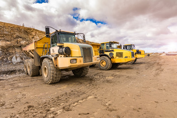 Fototapeta premium Large trucks in an open pit mine