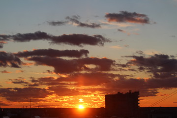 Clouds in the blue sky at sunset or dawn backlit by the sun. Place for text and design.