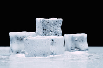 wet ice cubes with drops on a dark black background