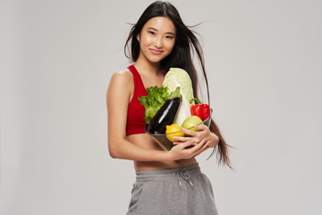 young woman holding a basket of vegetables