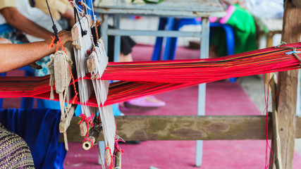 Tribal women are weaving with hand-made loom with wood, an ancient weaving machine inherited to ancestors and weaving is mostly for family use only.