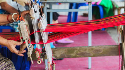 Tribal women are weaving with hand-made loom with wood, an ancient weaving machine inherited to ancestors and weaving is mostly for family use only.