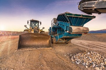 Fototapeta premium Excavator collecting stone in an open-cast mine