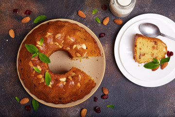 Round biscuit cake with almond nuts, raisins and dried cranberries. Delicious homemade dessert.