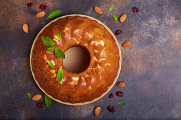 Round biscuit cake with almond nuts, raisins and dried cranberries. Delicious homemade dessert. Blank space for text