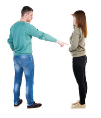 Back view of couple in sweater pointing.