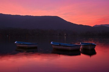 Puesta de Sol en el Lago con barcas vacías y la montaña de fondo