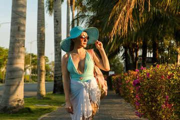 Fototapeta na wymiar girl in a hat on vacation goes to the beach