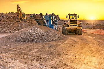 Excavator collecting stone in an open-cast mine