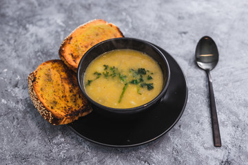 plant-based food, vegan cauliflower corn and onion soup with parsley topping and a side of garlic bread