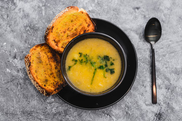 plant-based food, vegan cauliflower corn and onion soup with parsley topping and a side of garlic bread