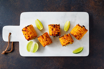 Roasted or grilled corn cob with olive oil and salt on a white marble tray. Tasty simple recipe,...