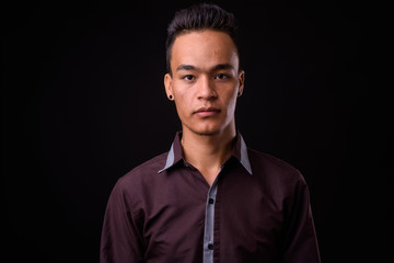 Obraz premium Portrait of young handsome Indian businessman looking at camera