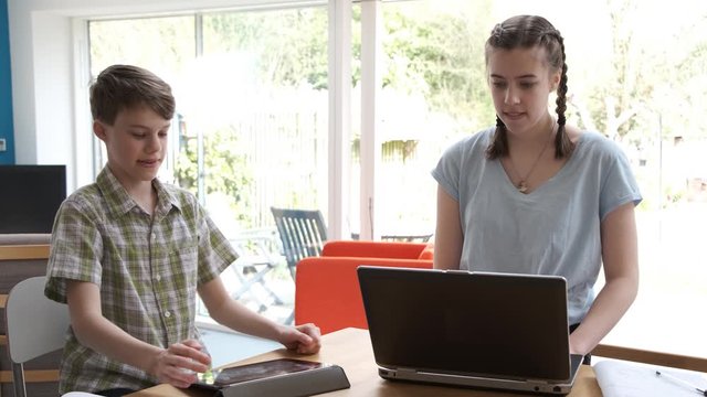 Home School Boy And Girl Working At Kitchen Breakfast Bar Because Of Coronavirus UK Lockdown Stay Home COVID-19